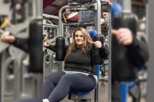 Kelly, a member of Genesis Ballarat, uses a chest press machine in the gym. After recovering from a serious motorbike accident, Kelly has been working hard to rebuild her strength and regain confidence, supported by the gym's facilities and community.